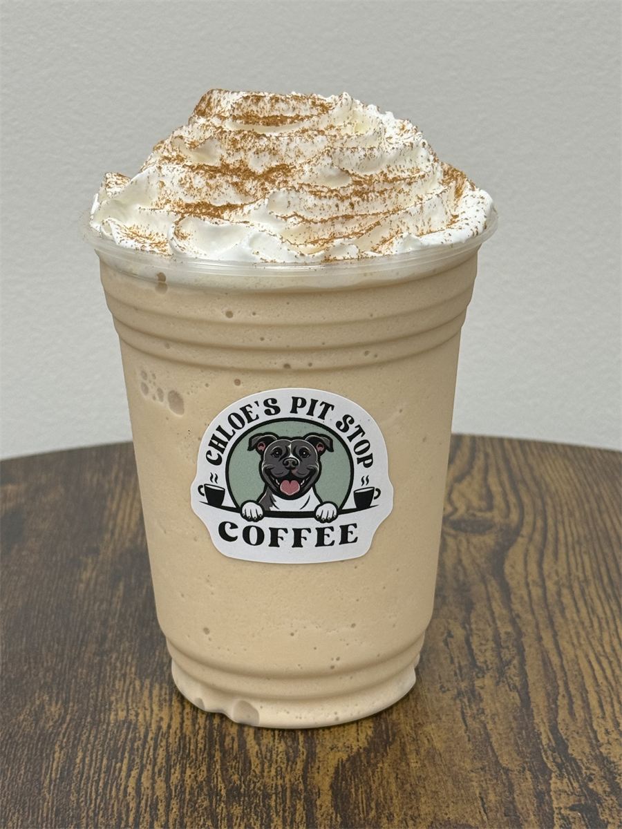 A blended frozen latte topped with whipped cream and cinnamon, marked with a Chloe's Pit Stop sticker